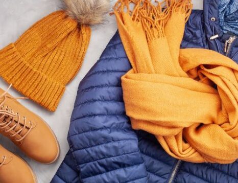 A blue puffer jacket and orange toque, scarf and boots
